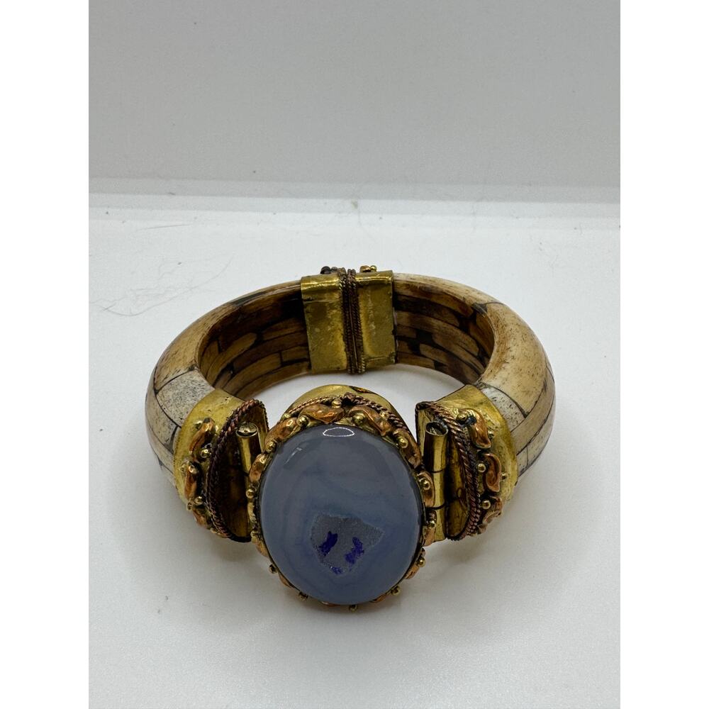 Blue dyed stone with drusy area, extensive mill work, bone bracket.